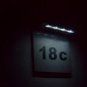 Numar de poarta cu lampa solara LED vazuta in noapte